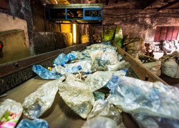 Plastic garbage on a conveyor belt at waste recycling factory